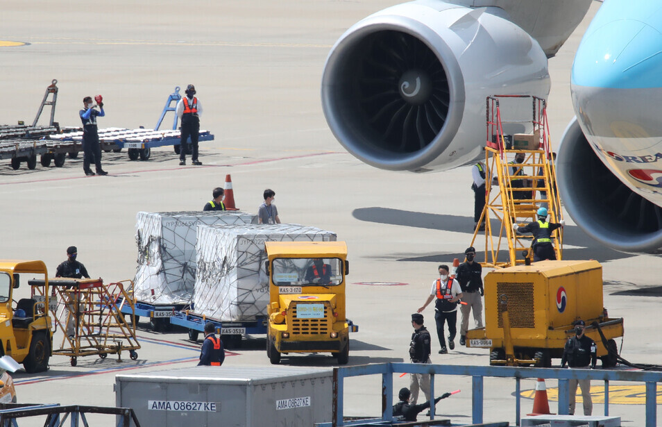 Incheon International Airport officials transport Moderna's COVID-19 vaccine doses that arrived in South Korea on Saturday at Incheon International Airport. (Yonhap News)