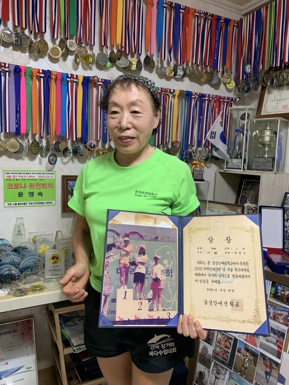 윤명숙씨가 30대 초반에 참가한 한 마라톤 대회 우승 상장과 기념사진을 들어 보이고 있다. 정인선