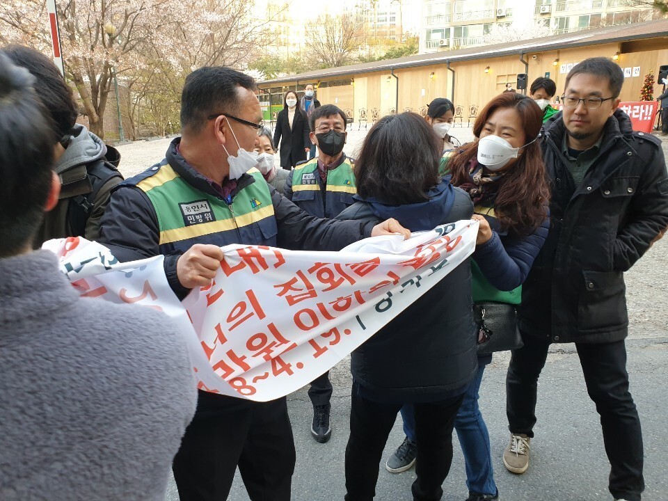 Followers of a church in Yongin, Gyeonggi Province, fight with public workers holding a banner telling people to refrain from public assemblies. (provided by Gyeonggi Province)
