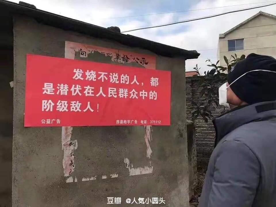 A Chinese man looks at a public announcement poster that reads, 
