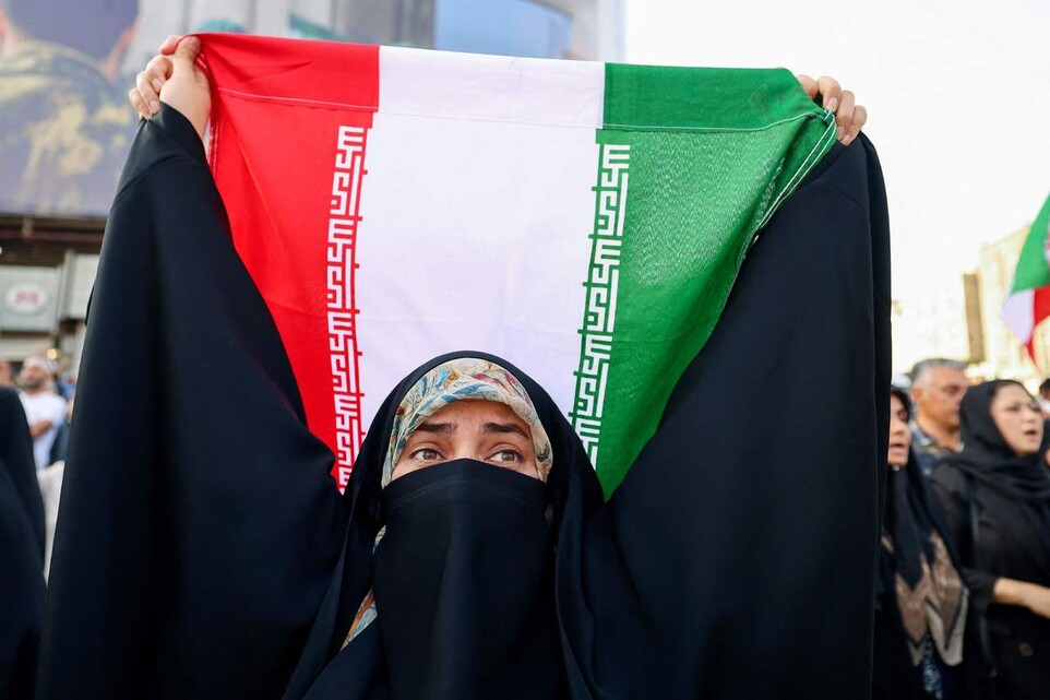 2025년 6월22일(현지 시각) 이란 테헤란의 엥헬랍 광장에서 열린 미국의 이란 공격에 항의하는 집회에서 한 이란 여성이 국기를 들어 보이고 있다. AFP 연합뉴스