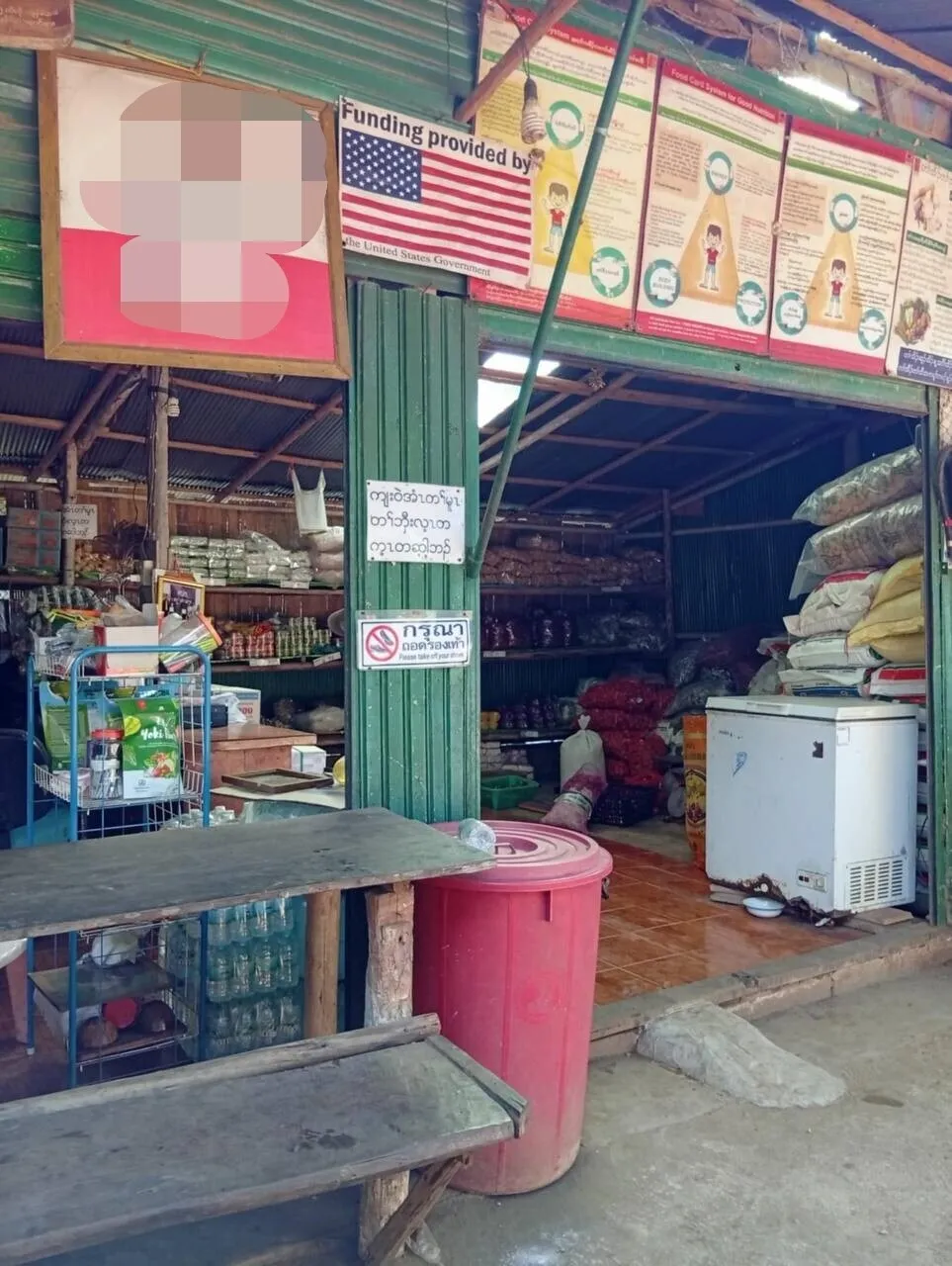 Signs reading “Funding provided by USA” are often seen on shops and buildings in Thailand’s Mae La camp, but Trump’s cuts to foreign aid will likely make them a thing of the past before long. (Claire Ham)