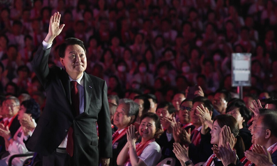President Yoon Suk-yeol stands and greets the crowd at an event commemorating the 69th founding anniversary of the Korea Freedom Federation held at the Jangchung Gymnasium on June 28. (courtesy of the presidential office)