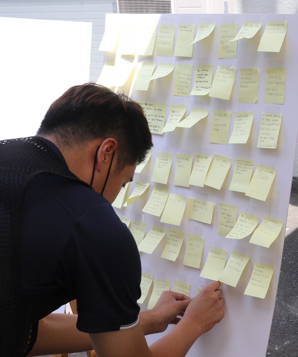 A person adds a handwritten note to a memorial on the Inha University campus for a young woman who fell to her death on campus after being sexually assaulted. (Yoon Woon-sik/The Hankyoreh)
