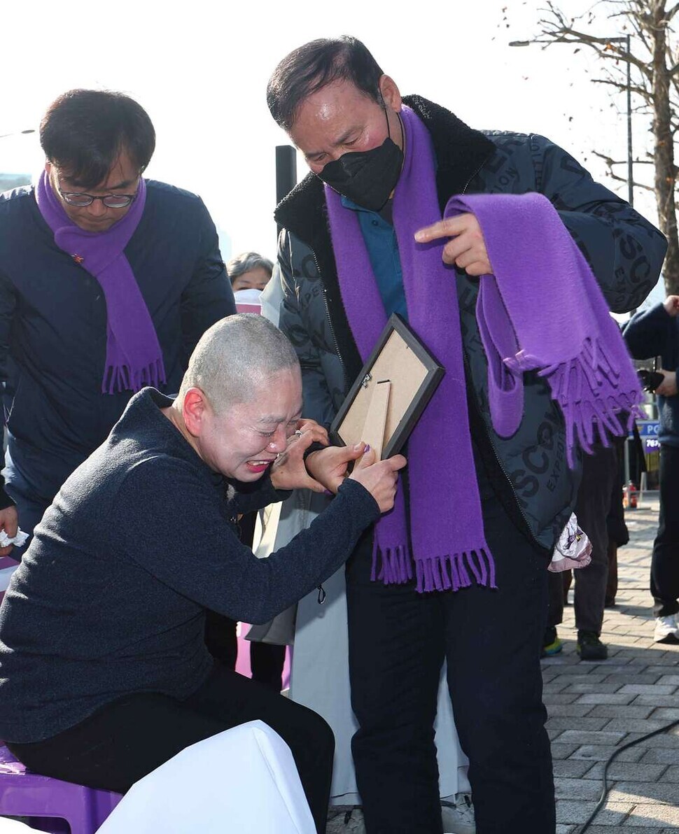 The parent of a person who died in the tragic crowd crush in Itaewon on Oct. 29, 2022, wails with family outside the presidential office in Seoul on Jan. 18 after shaving her head in protest of the ruling People Power Party’s recommendation that the president use his veto power on a special act for investigating the disaster. (Yonhap)