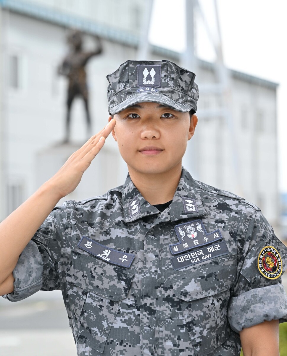 문희우 해군 중위가 심해잠수사 휘장을 달고 해난구조대 잠수사 동상 앞에서 거수 경례를 하고 있다. 해군 제공