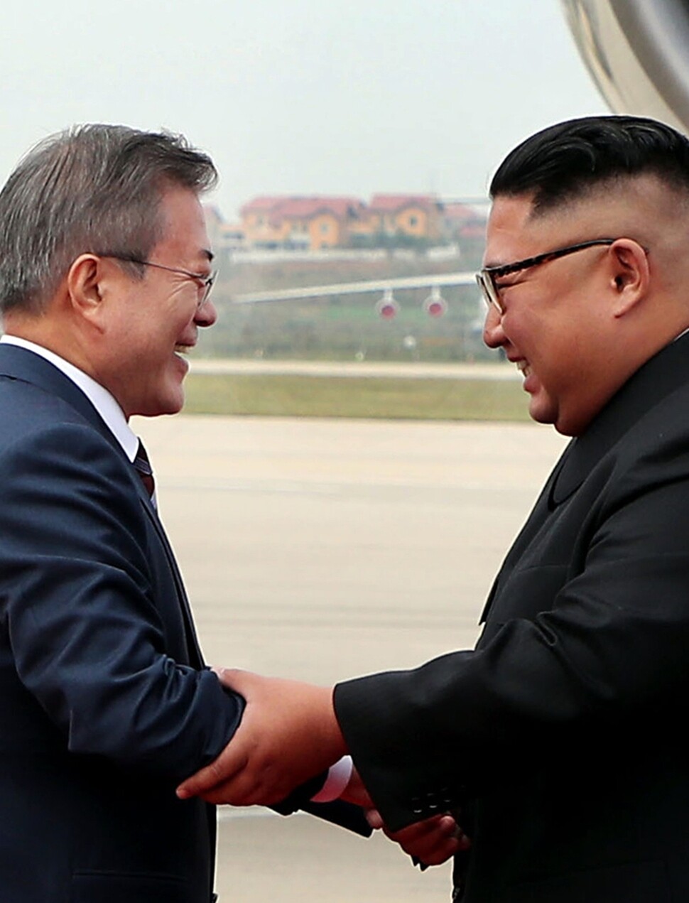 문재인 대통령과 김정은 위원장이 반갑게 손을 잡으며 다가서고 있다.