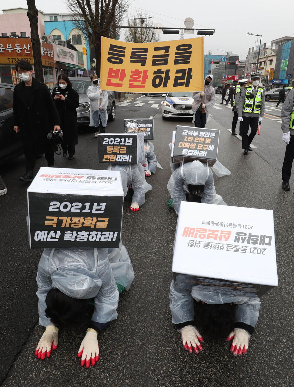 South Korean college students hold a “three steps, one bow” march Sunday from Gyeongbokgung Station to the Blue House to demand tuition refunds. (Park Jong-shik/The Hankyoreh)