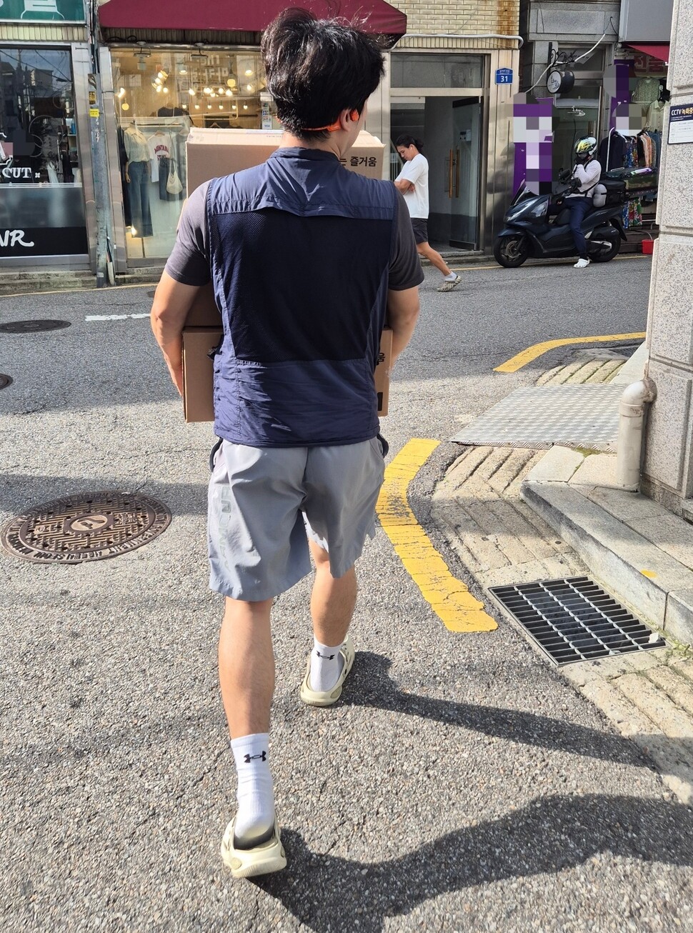 2025년 7월22일 택배기사 ㄱ씨가 ‘쓱배송’ 택배 세 상자를 안고 바쁘게 걸음을 옮기고 있다. 신다은 기자