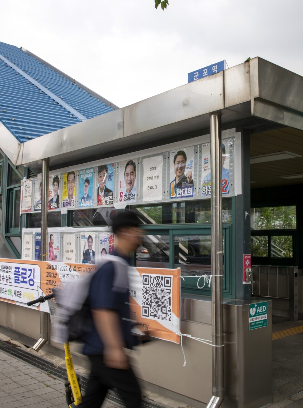 2022년 5월30일 6·1 지방선거 벽보가 붙은 경기도 군포시 당동의 지하철 군포역 들머리로 한 시민이 걸어가고 있다. 김진수 선임기자