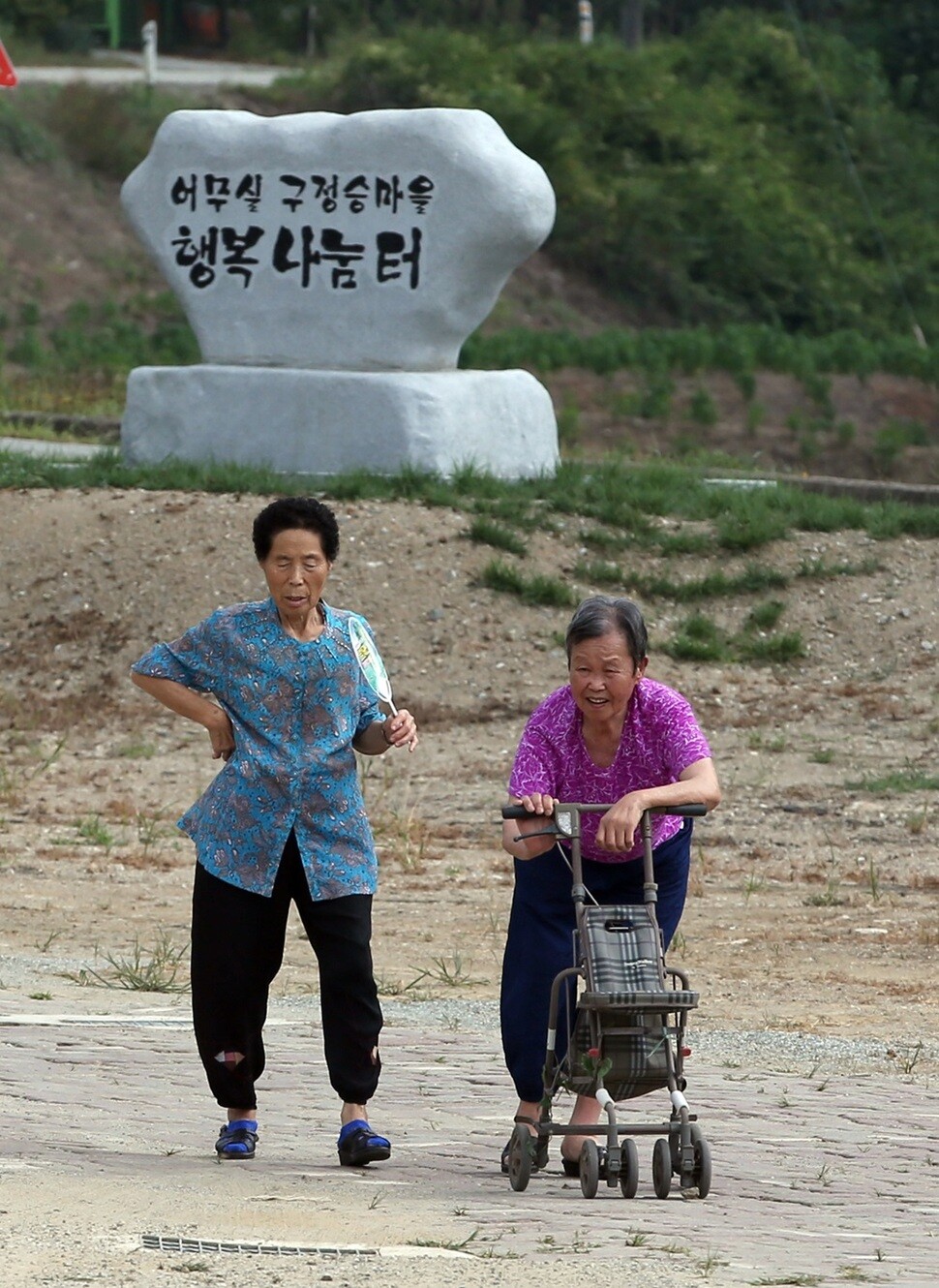 거동이 불편한 마을 주민이 보조기구를 이용해 마을회관으로 걸어오고 있다.