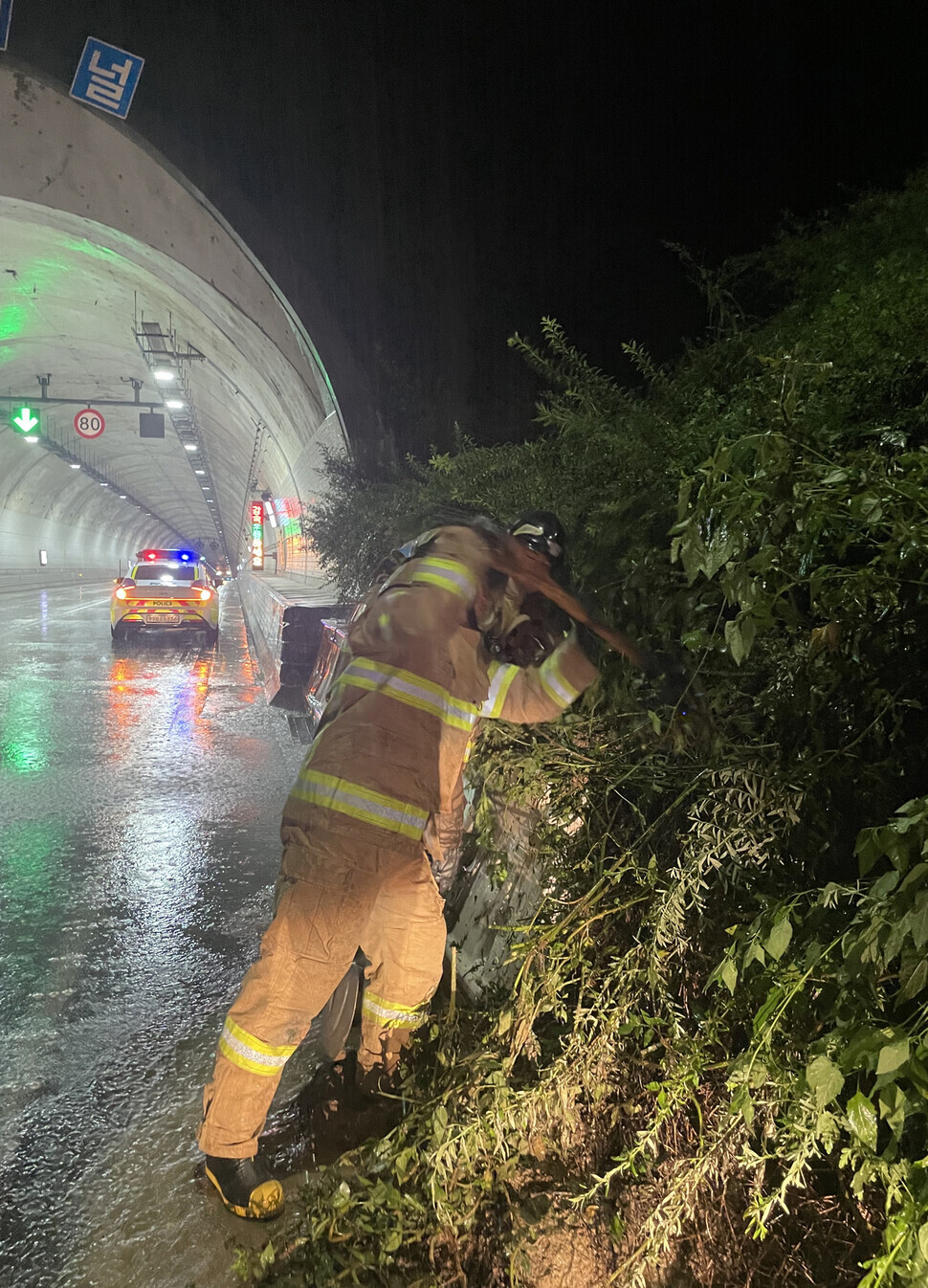 An emergency responder removes debris that had spilled into a road leading into the Gise Tunnel in Dalseong Country, Daegu, in the early hours of Sept. 6. (courtesy Daegu Fire & Safety Department)