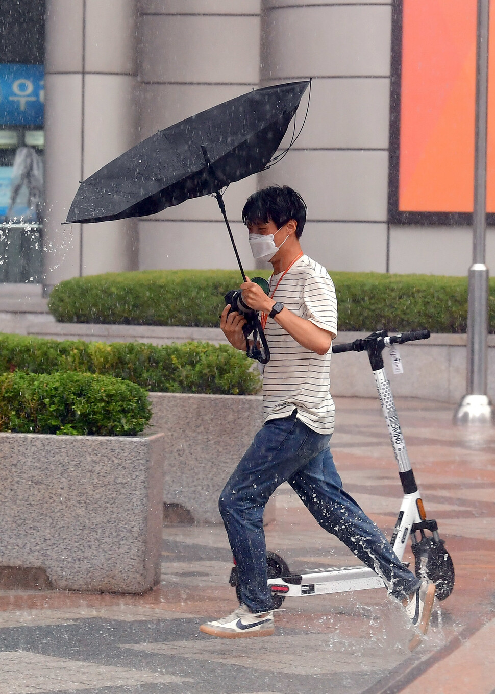 수도권에 많은 비가 내린 2022년 8월6일 폭우 피해 취재에 나선 한 사진기자가 뒤집힌 우산을 들고 현장으로 달려가고 있다. 국민일보 제공