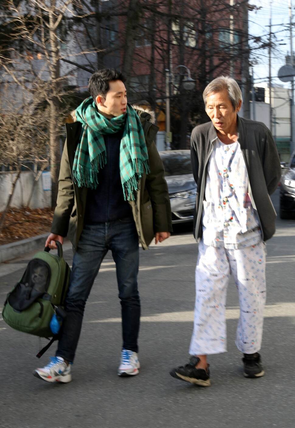 치매가 있는 아버지를 9년간 돌보는 조기현(왼쪽)씨가 2020년 1월16일 경기도 부천의 한 요양병원 앞에서 아버지와 함께 이야기를 나누며 걷고 있다. 한겨레 자료