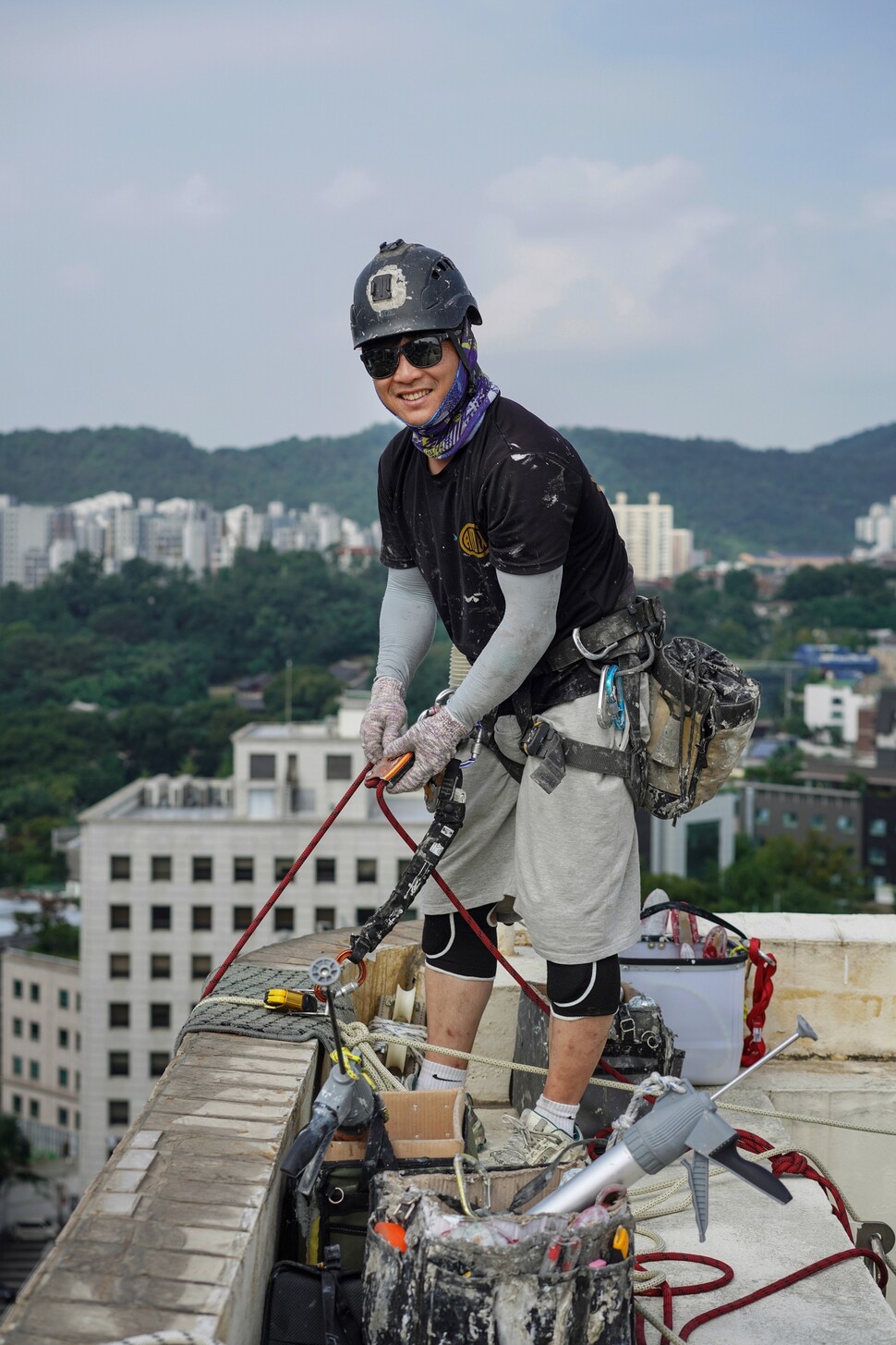 작업 직전, 그의 몸에 벨트와 카라비너, 디(D)링, 로프, 파우치 등이 잔뜩 달린다.