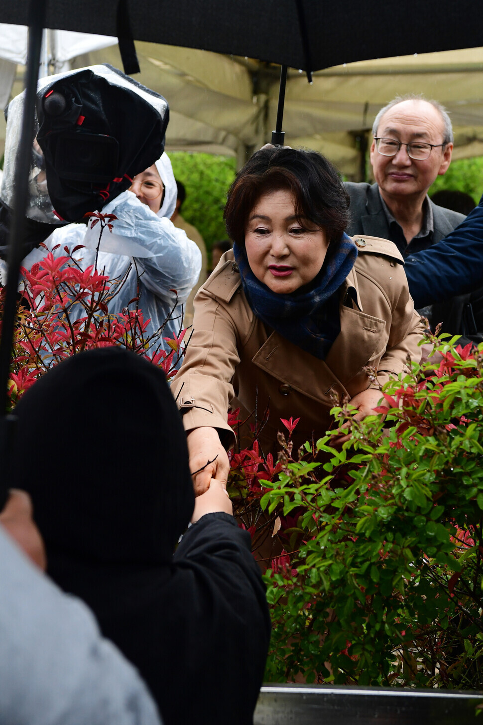Kim Jung-sook, the former first lady, shakes hands with a visitor outside the former president’s bookshop in Pyeongsan, a village in the South Gyeongsang Province city of Yangsan on April 25. (pool photo)