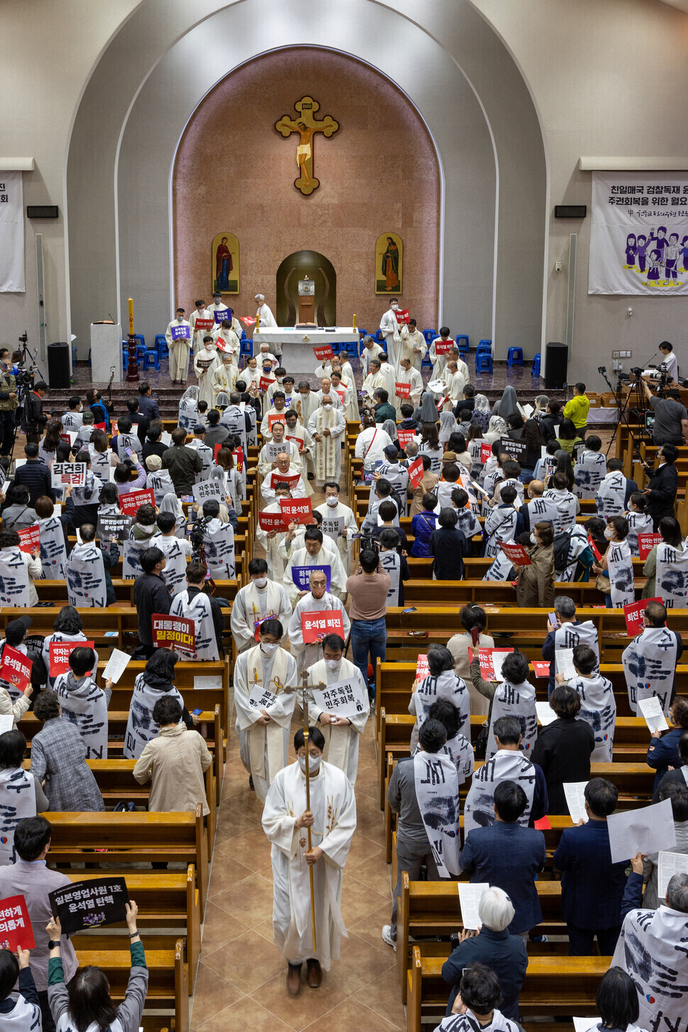 Members of the Catholic Priests' Association for Justice march out of a cathedral in Suwon on April 24 following their prayer meeting there. (Park Seung-hwa/The Hankyoreh)