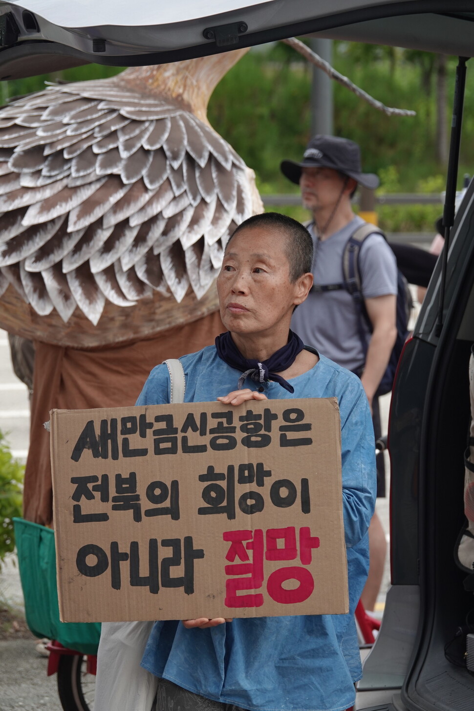 2025년 8월12일 오전 전북 전주시 전북지방환경청 앞에서 열린 ‘새만금 신공항 취소 판결을 바라는 새, 사람 행진’ 출발을 알리는 기자회견에서 경남 하동에서 온 조성원씨가 ‘새만금 신공항은 전북의 희망이 아니라 절망’이라고 쓰인 손팻말을 들고 있다. 김양진 기자