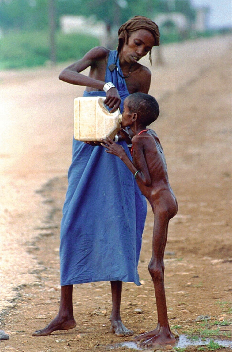 굶주림에 지친 소말리아 어린이가 1992년 12월14일 소말리아 바이도아 지역 난민캠프에서 물을 받아 마시고 있다.