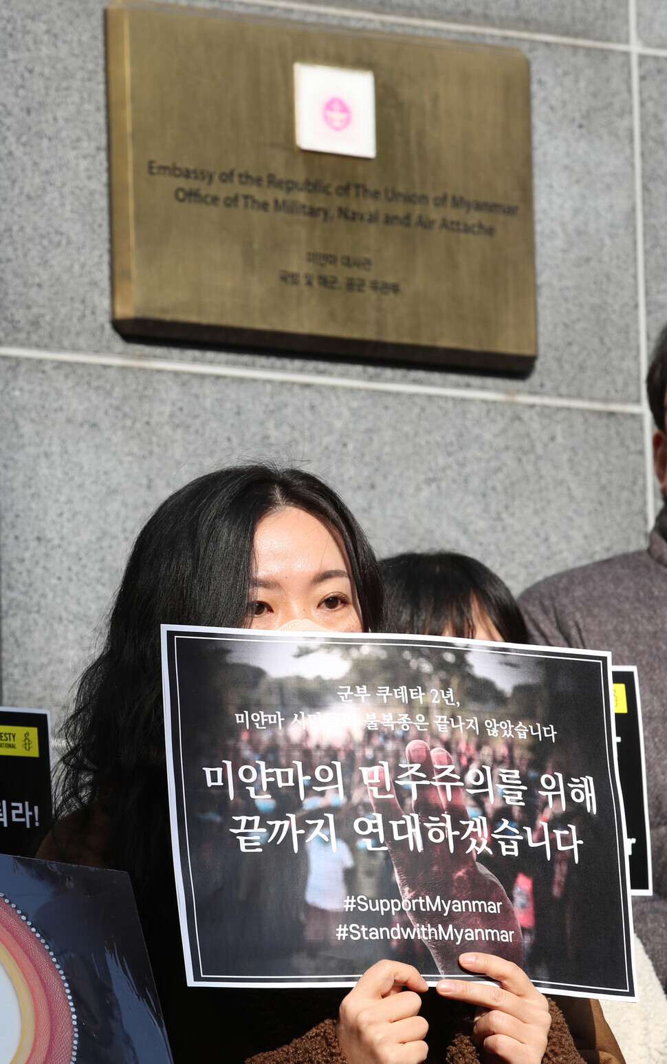 A supporter of democracy in Myanmar holds a sign outside the Myanmar Embassy in Seoul on Feb. 1 to condemn the two-year rule of the military junta following a coup and to call for democracy in Myanmar. (Shin So-young/The Hankyoreh)