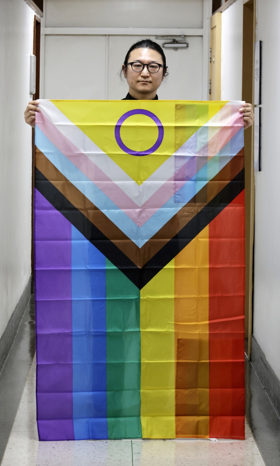 퀴어문화축제에서 성소수자를 축복한 일로 기독교대한감리회로부터 정직 2년의 벌칙을 받았던 이동환 목사가 2025년 4월28일 크리스천 퀴어·앨라이 운동단체 ‘큐앤에이’ 사무실 앞에서 성소수자를 상징하는 깃발을 들고 있다. 김명진 기자 littleprince@hani.co.kr