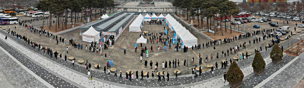 Lines of people wait outside a temporary COVID-19 screening station in Seoul’s Mapo District on Sunday. (Kim Hye-yun/The Hankyoreh)