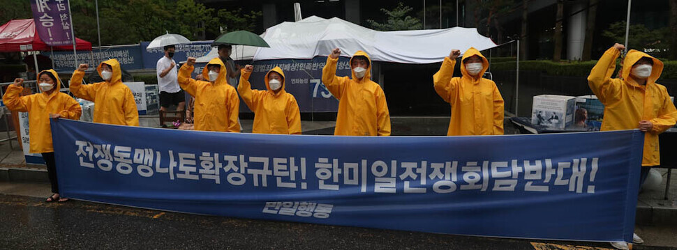 Members of Anti-Japan Action stand in the rain outside the former Japanese Embassy in downtown Seoul on June 29, chanting their opposition to the expansion of NATO and the trilateral summit of South Korea, the US, and Japan. (Kim Jung-hyo/The Hankyoreh)