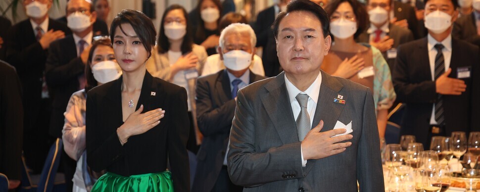 President Yoon Suk-yeol and first lady Kim Keon-hee pledge allegiance to the flag during a luncheon for Korean compatriots in Madrid, Spain, on June 29, 2022. (Yonhap)