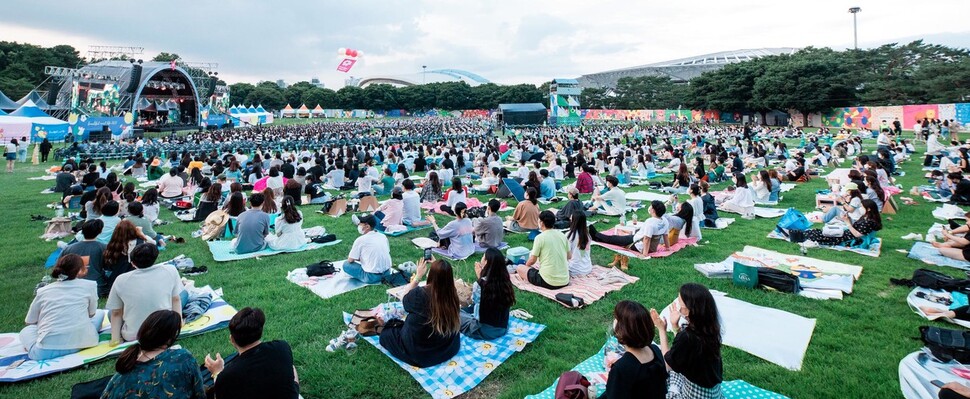 지난 26일 오후 서울 송파구 올림픽공원 88잔디마당에서 열린 야외음악축제를 찾은 관객들이 돗자리에 앉아 공연을 즐기고 있다. 민트페이퍼 제공
