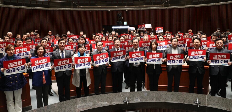 Leader Lee Jae-myung of the Democratic Party stands with members of his party in the plenary session of the National Assembly on Jan. 30 holding placards calling for a special prosecutor to be assigned to Kim Keon-hee. (Kim Bong-kyu/The Hankyoreh)