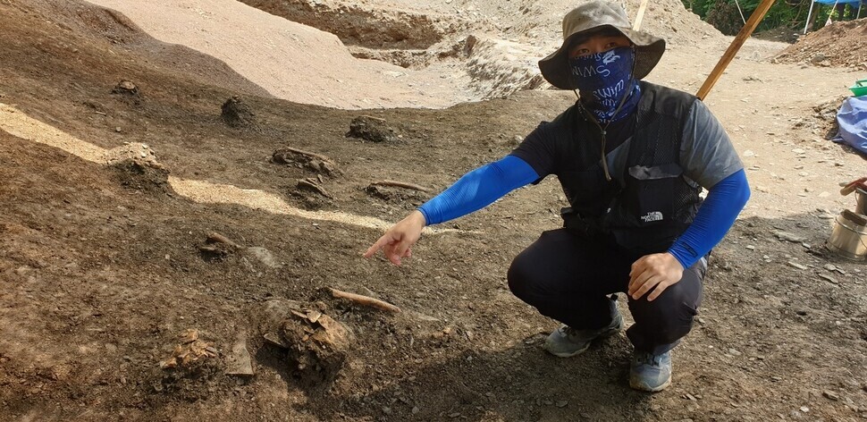 A researcher points to the remains of a Daejeon massacre victim at an excavation site in Daejeon. (Choi Ye-rin/The Hankyoreh)
