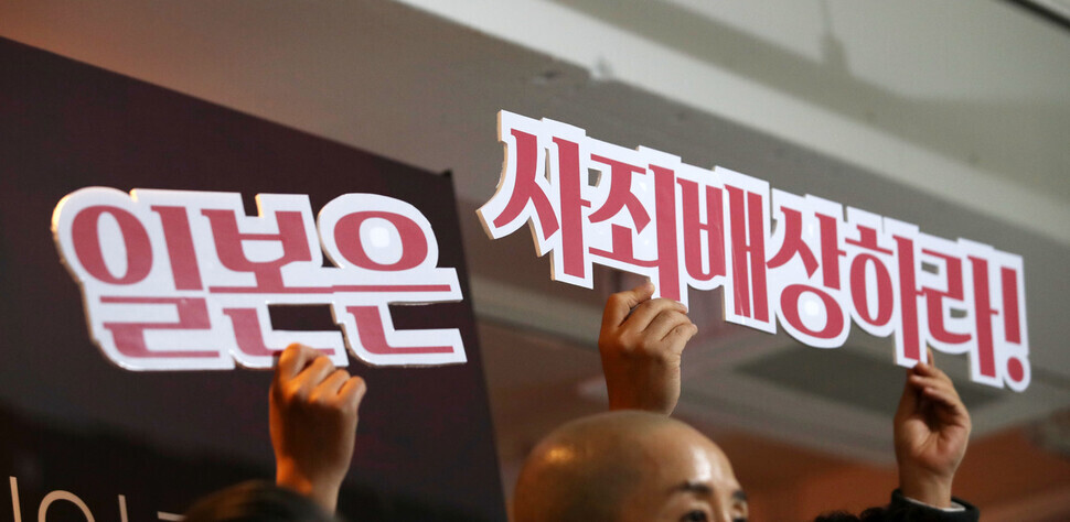 Participants in the press conference hold up pickets calling for Japan to apologize to and compensate victims of forced labor. (Kim Hye-yun/The Hankyoreh)
