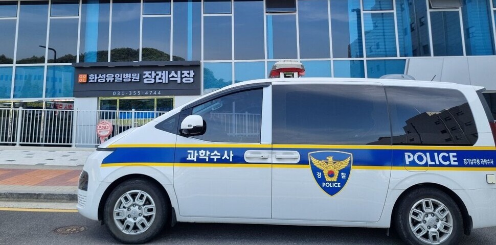 A police forensics vehicle parks in front of the mortuary and funeral hall at Hwaseong Yuil Hospital, where some of those killed in the fire at a lithium battery factory were brought. (Go Na-rin/The Hankyoreh)