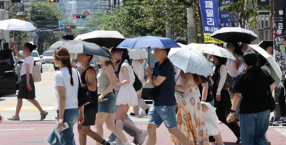 Citizens walking with parasols on a Seoul street during extreme heat