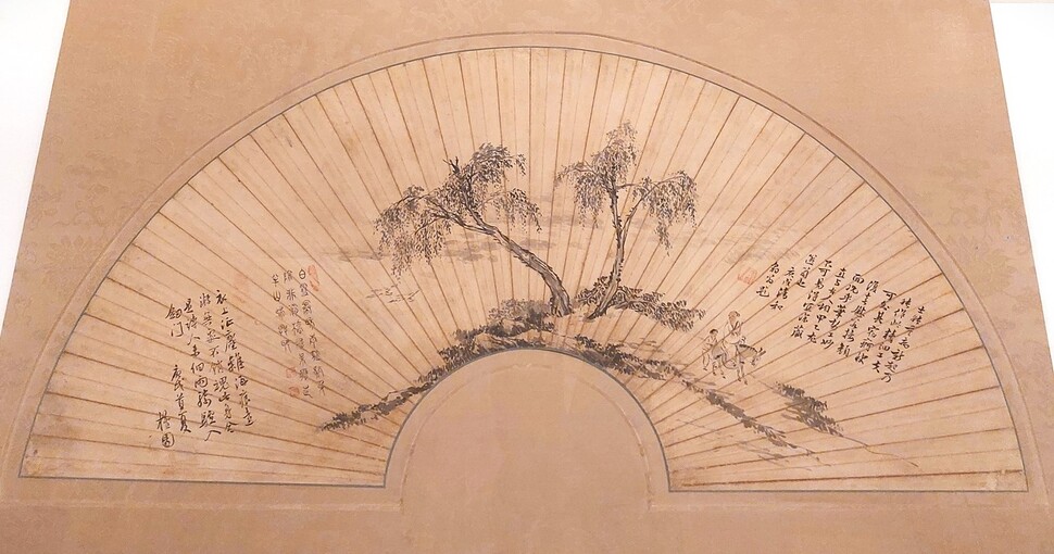이번 전시의 대표작 중 하나로 꼽히는 18세기 회화 거장 단원 김홍도의 부채 그림. ‘기려원류’라는 제목으로 두개의 버드나무 아래 난 길로 나귀 타고 멀리 유람을 떠나는 늙은 도인의 모습을 그렸다. 노형석 기자
