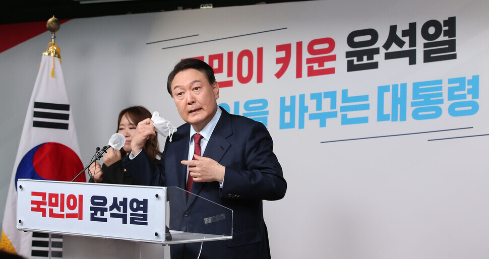 Yoon Suk-yeol, presidential candidate for the major opposition People Power Party, removes his mask to announce campaign pledges relating to judicial reform during an event on Monday. (pool photo)
