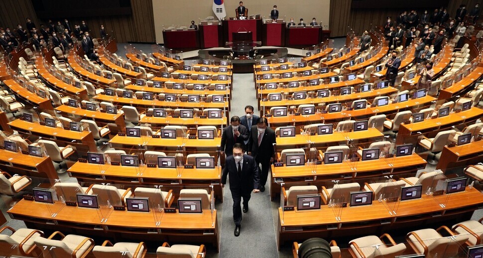 President Yoon Suk-yeol exits the National Assembly hall in a corridor between seats left empty by Democrats’ boycott of his budget speech on Oct. 24. (Kim Bong-gyu/The Hankyoreh)
