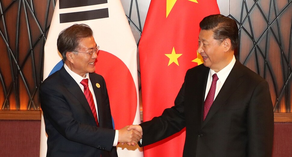 South Korean President Moon Jae-n and Chinese President Xi Jinping smile as they shake hands to open their summit at the Crown Plaza Hotel in Da Nang