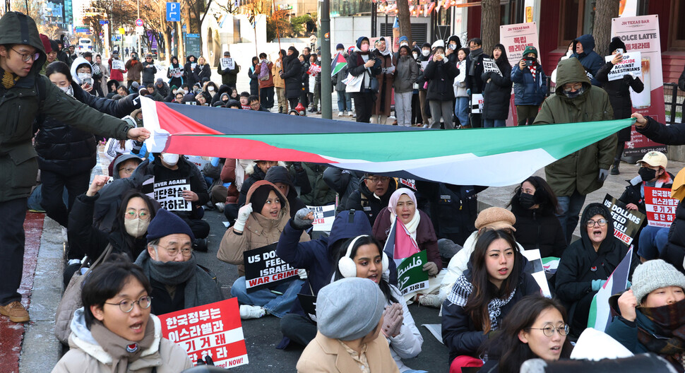 ‘팔레스타인과 연대하는 한국 시민사회 긴급행동’이 2024년 1월7일 주한 이스라엘대사관이 있는 서울 종로구 서린동 청계한국빌딩 맞은편에서 연 집회에서 국내에 거주하거나 여행 중인 외국인들이 시민들과 함께 대형 팔레스타인 국기를 머리 위로 넘기며 ‘프리 팔레스타인'을 외치고 있다.