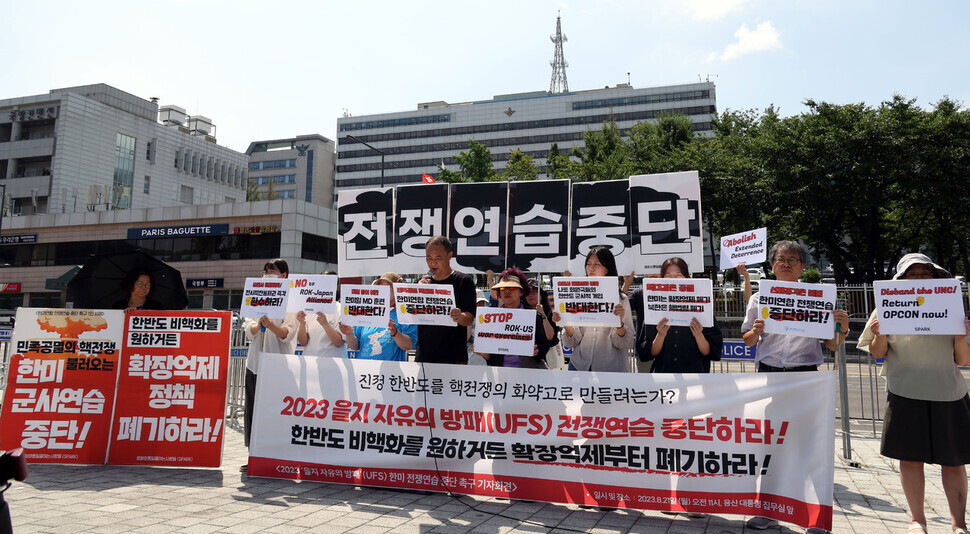 Members of the group Solidarity for Peace and Reunification of Korea hold a press conference with signs and a banner outside the presidential office in Seoul on Aug. 21, where they call on Seoul and Washington to call off the upcoming Ulchi Freedom Shield joint drill. (Kim Gyoung-ho/The Hankyoreh)
