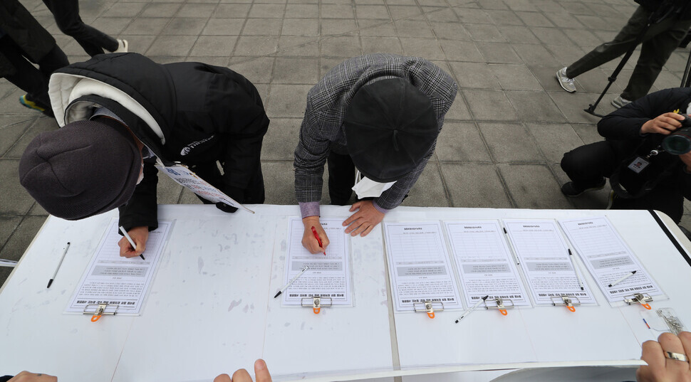 People sign their names to Joint Action for Historical Justice and Peaceful Korea-Japan Relations’ signature campaign to void the Yoon Suk-yeol administration’s proposed plan for compensating victims of Japan’s forced labor mobilization. (Kim Hye-yun/The Hankyoreh)