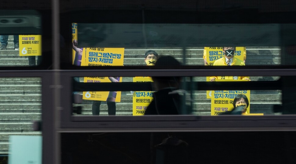 버스를 탄 시민들이 4월6일 정의당 지도부가 서울 종로구 세종문화회관 계단에서 ‘엔(n)번방 방지·처벌법’ 처리를 촉구하는 모습을 바라보고 있다.
