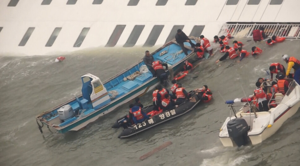 2014년 4월16일 전남 진도군 관매도 인근 해상에서 세월호가 침몰하는 가운데 해경이 구조활동을 하고 있다. 서해지방해양경찰청 제공