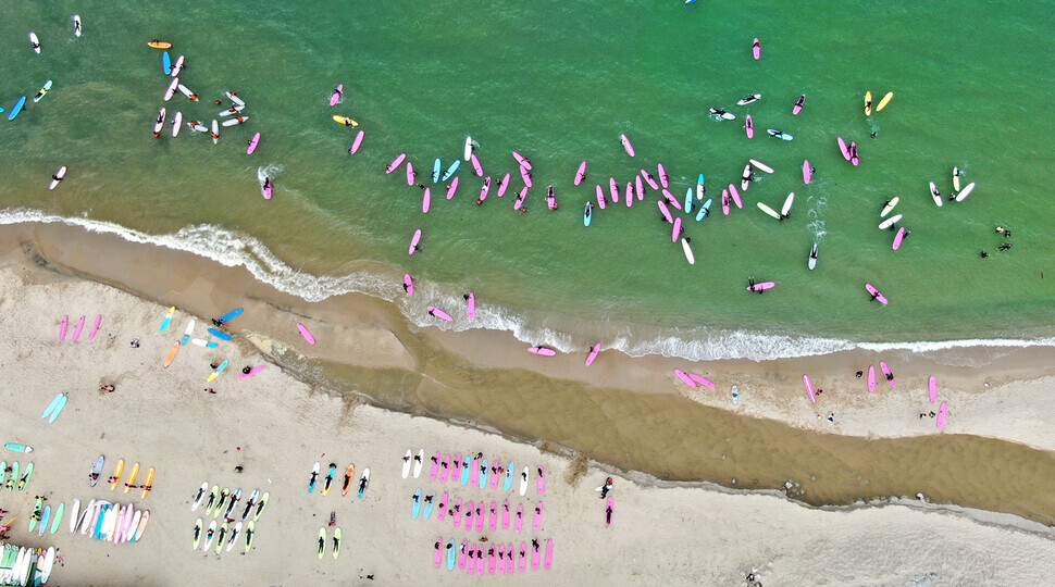 Beach-goers give surfing a shot on July 28 at Ingu Beach in Yangyang, Gangwon Province. (Lee Jeong-yong/The Hankyoreh)