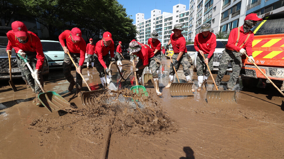 Marines shovel away mud and soil dredged up by the typhoon when torrential downpours caused a nearby stream to overflow. (Kim Jung-hyo/The Hankyoreh)