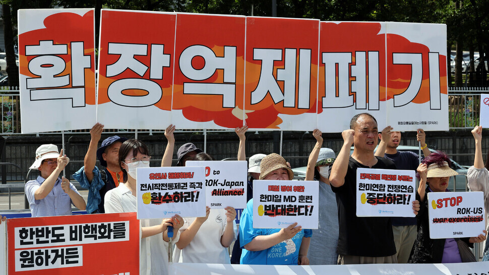 Members of the group Solidarity for Peace and Reunification of Korea hold a press conference with signs reading “Abolish extended deterrence” outside the presidential office in Seoul on Aug. 21, where they call on Seoul and Washington to call off the upcoming Ulchi Freedom Shield joint drill. (Kim Gyoung-ho/The Hankyoreh)