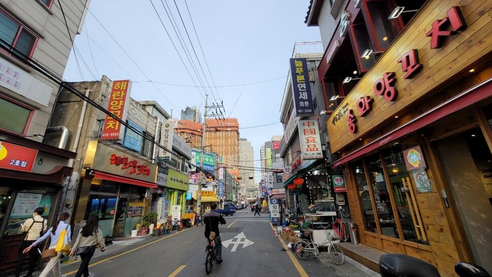 서울 광진구 자양4동의 ‘양꼬치 거리’ 모습. 뒤쪽에 호반건설이 짓고 있는 고층 아파트가 보인다.