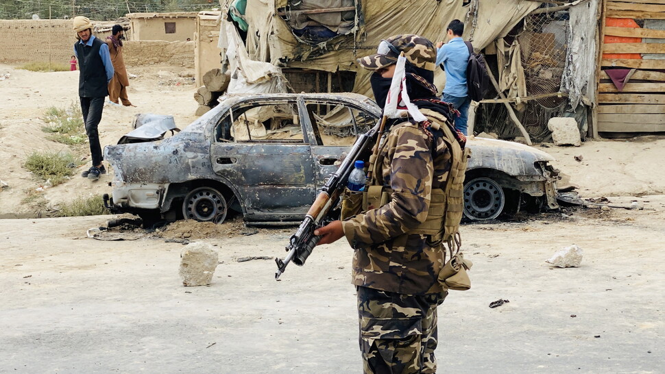 미국의 아프가니스탄 철수 시한이 임박한 2021년 8월30일, 카불 국제공항을 겨냥한 여러 발의 로켓 포탄 발사에 쓰인 자동차 주변 현장을 탈레반 전투원들이 통제하고 있다. 이 테러의 배후는 확인되지 않았다. 미군이 드론 공격으로 이 차량을 파괴하는 과정에서 민간인 일가족 9명이 목숨을 잃은 것으로 알려졌다. AFP 연합뉴스