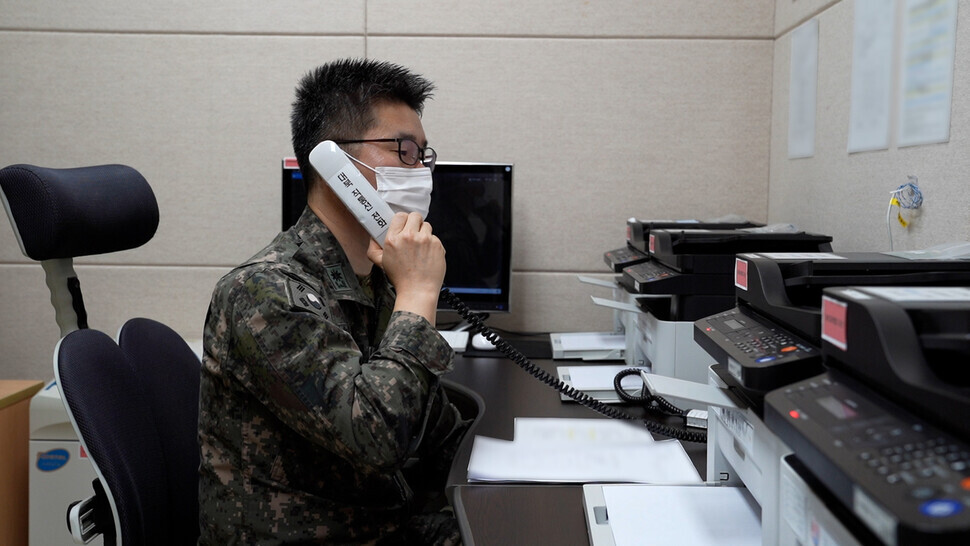 A South Korean military officer speaks over the phone with a North Korean military counterpart on Monday morning via an inter-Korean direct communication line. Direct communication lines in the inter-Korean liaison office and military communication lines along the eastern and western coasts were restored that day, allowing for landline phone communication and document exchanges via fax. (provided by the Ministry of National Defense)