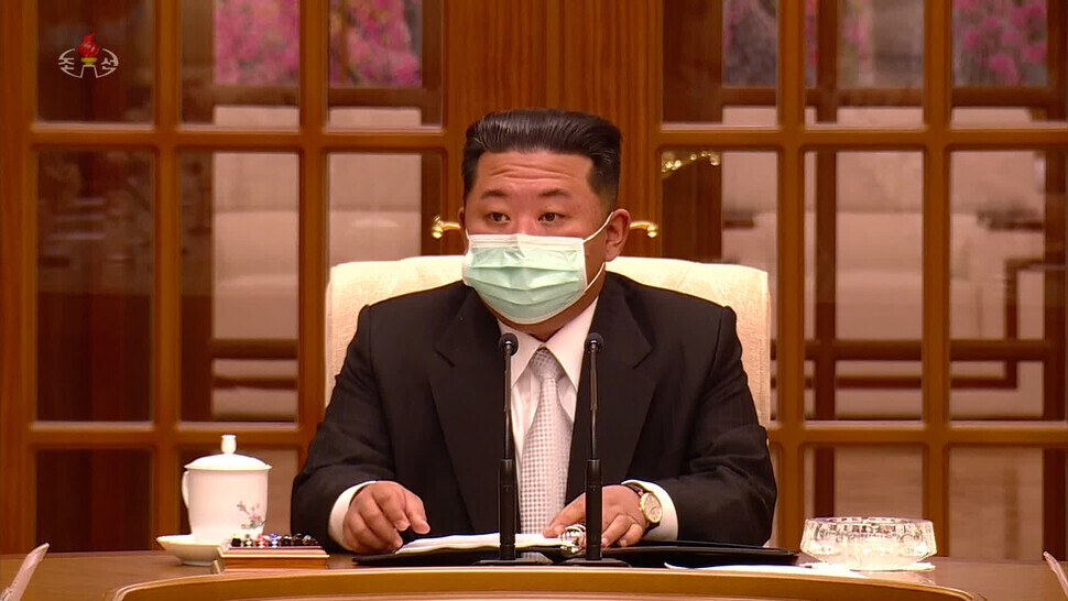 North Korean leader Kim Jong-un dons a mask while attending a meeting of the WPK Politburo on May 12, the first time he has been seen wearing a mask on North Korean media. (still from Korean Central Television/Yonhap News)